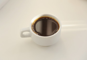 Black coffee in white cup on white background