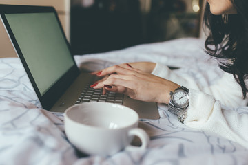 Close up woman lying bed using computer