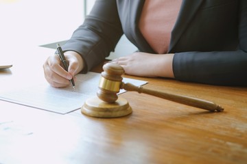 Legal counsel presents to the client a signed contract with gavel and legal law. justice and lawyer concept .