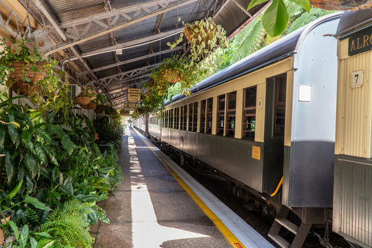 Tourist train journey. Kuranda Scenic Railway Train across rainforest, jungles. Train, train tracks, passenger seats, interior, skyrail, bridge, mountains and landscape.