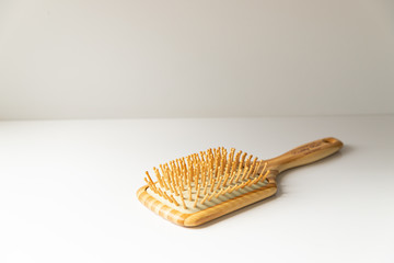 Wooden massage hairbrush isolated on white background