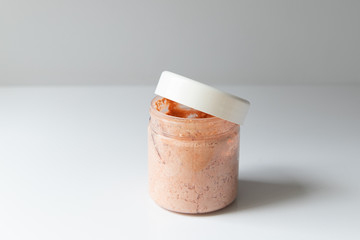 Cosmetic jar with scrub cream on a white background