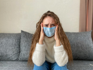 woman Working from home wears a protective medical mask. The concept of home quarantine.