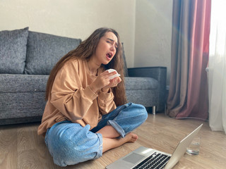 Obraz premium young woman remains isolated at home with signs of a viral infection. A woman on outpatient treatment. home quarantine concept, coronavirus.