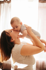 Happy cheerful family. Mother and baby kissing, laughing and hugging