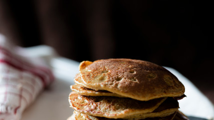 OAT PANCAKES WITH SYRUP ON A BLACK BACKGROUND