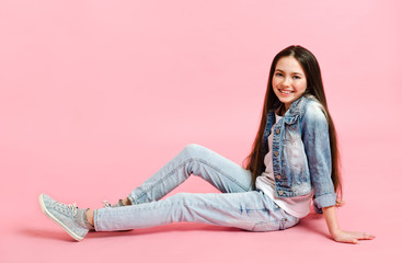 Portrait of adorable smiling little girl child preteen in jeans isolated