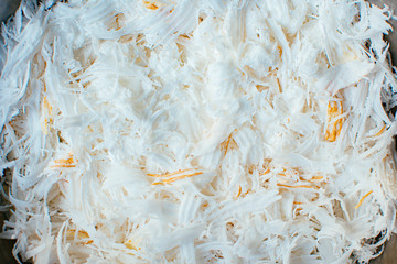 Fresh coconut flakes background. Detail of dried shaved coconut flakes. 
