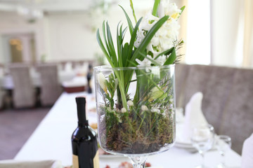 Wedding. Banquet. The chairs and round table for guests, served with cutlery, flowers and crockery and covered with a tablecloth