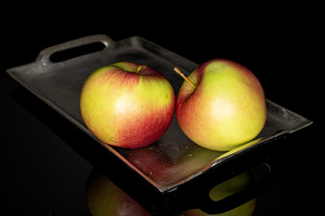Group of two whole fresh garden apple on tray isolated on black glass