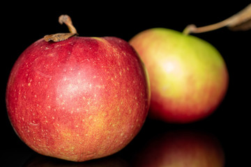 Group of two whole fresh garden apple closeup isolated on black glass