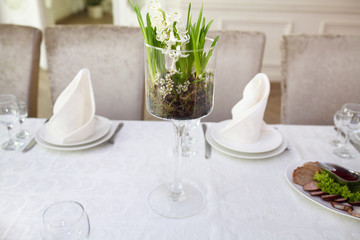 White table setting from above. Elegant empty plate, cutlery, napkin and glass on shabby chic or vintage planked wood table.