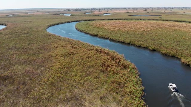 Boat Riding On The Long Okavango Delta River In Botswana - Aerial Drone Shot