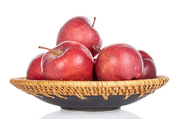 Lot of whole red delicious apple on plate with braided edge isolated on white