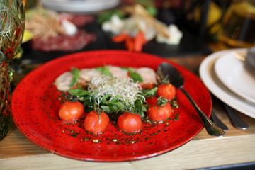 Beautifully decorated catering banquet table with profiteroles, salads and cold snacks. Variety of tasty delicious snacks on the table. Wedding table serving. Meat and vegetables