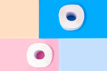 Two white  toilet paper rolls on colored background. Copy space for text, flat lay. Hygiene products