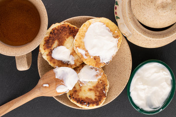 Group of three whole cheese pancake with cream on grey stone