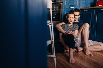 Fototapeta na wymiar A young couple is at home sitting in the kitchen in an embrace