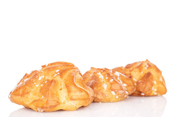 Group of three whole fresh baked profiterole isolated on white