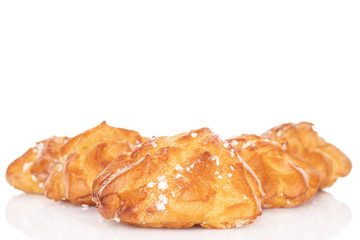 Group of five whole sweet fresh baked profiterole isolated on white