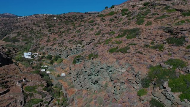 Aerial shot of a classic cycladic landscape, on the Greek island of Sifnos. Camera flies through a gorge.
