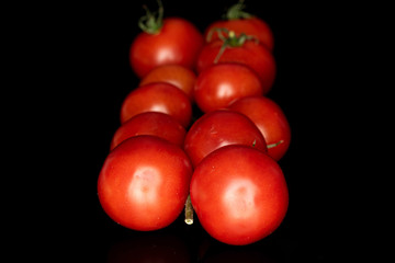 Lot of whole shiny fresh red cherry tomato isolated on black glass