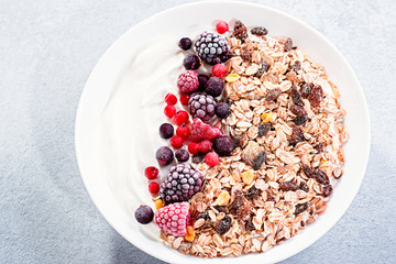Muesli bowl or granola bowl with yogurt and berries on concrete table top. Healthy breakfast, top view. Dish suitable for diet, healthy lifestyle