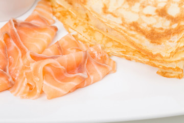 Fragment of breakfast with salmon and pancake.
