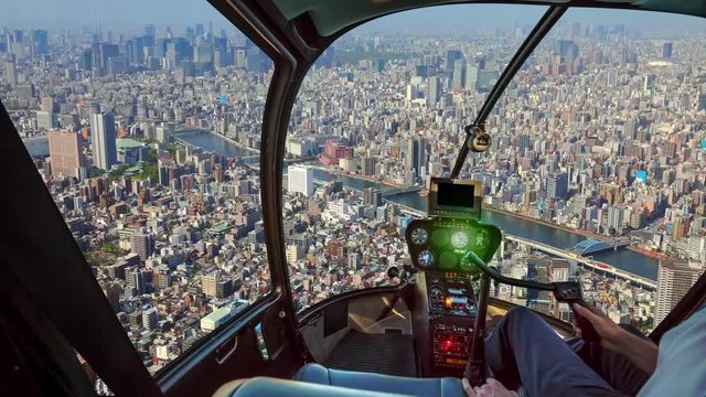 Helicopter cockpit inside the cabin flying on Tokyo cityscape. Sumida district, Japan. Sunny day in TIME LAPSE.