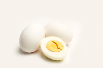Huevos blancos enteros y por la mitad sobre fondo blanco aislado. Vista de frente. Copy space