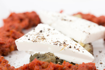 Fragment of aubergine appetizer with red sauce.