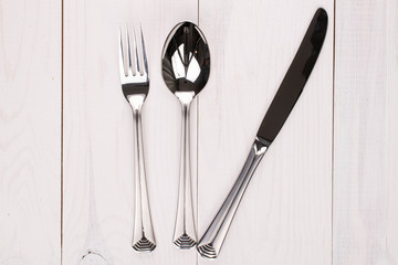 Spoon fork and knife on white wood