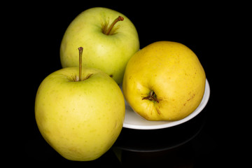 Group of three whole green delicious apple isolated on black glass