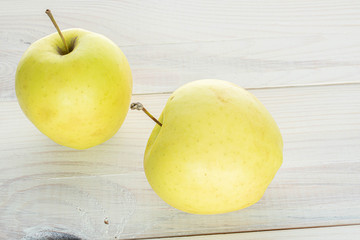 Group of two whole green delicious apple on white wood
