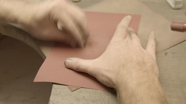 goldsmith smoothes a ring with emery paper