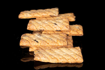 Lot of whole flat square puff cookie with raisins isolated on black glass