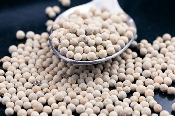 peppercorns, White pepper in the spoon and in the background