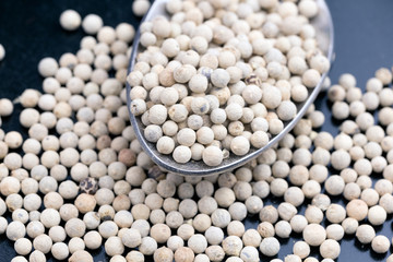 peppercorns, White pepper in the spoon and in the background