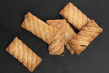 Lot of whole square puff cookie with raisins on grey stone