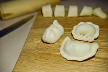 Fototapeta na wymiar three dumplings of different shape on the wooden deck.