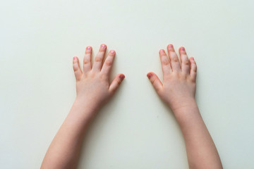 Small children's hands on a white table