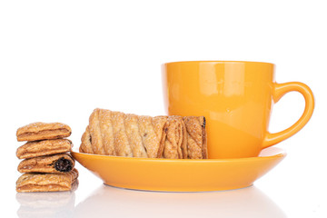 Fototapeta na wymiar Lot of whole square puff cookie with raisins with tea cup isolated on white