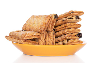 Lot of whole square puff cookie with raisins on yellow plate isolated on white