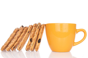 Lot of whole square puff cookie with raisins with yellow cup isolated on white