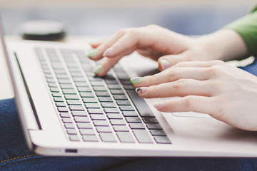 Hands of woman on the laptop keyboard