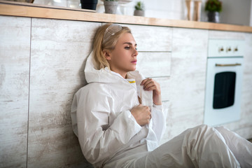 Blonde woman in white workwear feeling bad