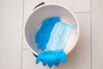 Used blue medical latex gloves and disposable protective masks in the bin. Problem of the disposal...
