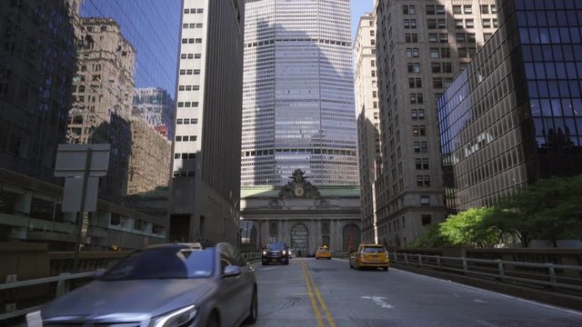 Tilt up as NYC taxi traffic passes on Park Ave bridge at Grand Central Terminal