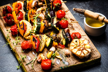 Serving Grilled BBQ Vegetables Skewers with Fresh Herbs, Marinate and Spices on Wooden Board