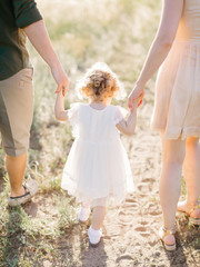 Happy family concept - father, mother and child daughter having fun and playing in nature.